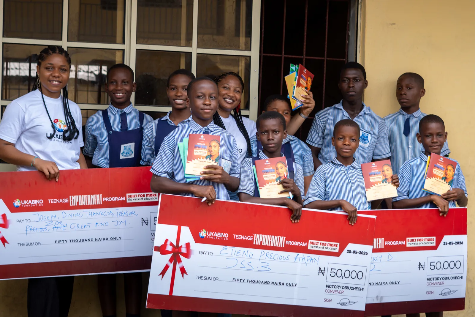 Students and guests displaying support cheques