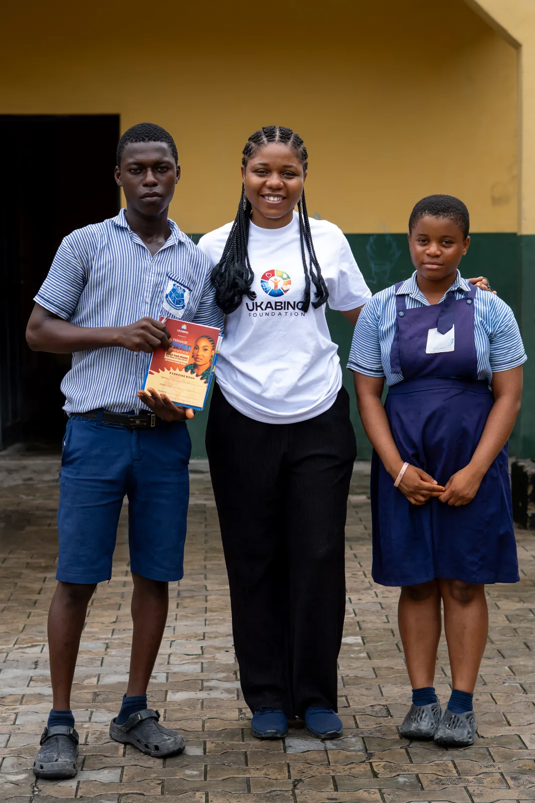 Students holding books with volunteers